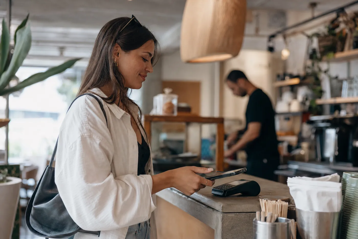 A woman paying with her phone at an Auckland cafe